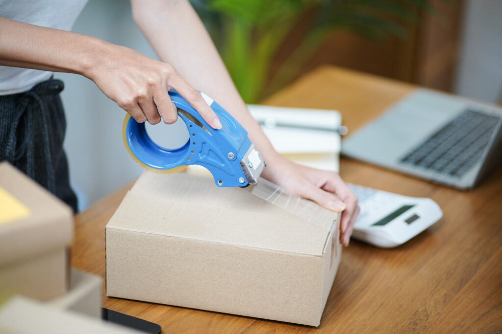 Welpac packaging company Description with modified keywords: A woman is wrapping a box for international shipping.