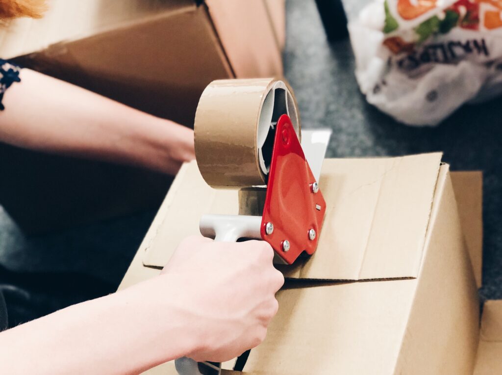 Welpac packaging company A woman is wrapping a box with tape, showcasing innovative packaging designs.