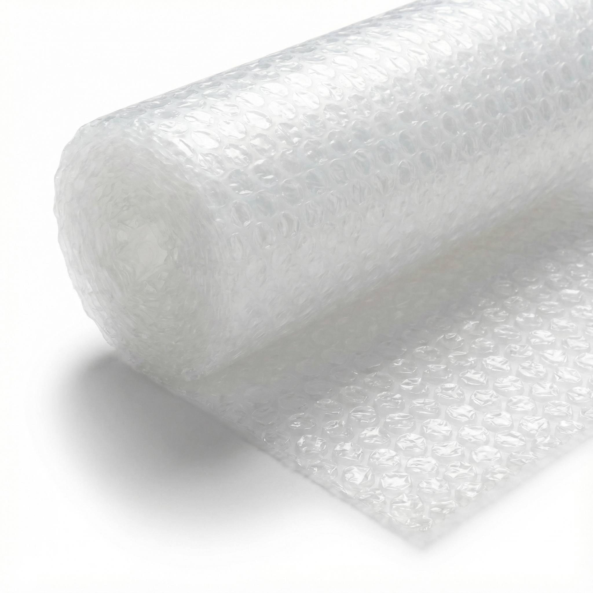 A roll of clear bubble wrap partially unrolled on a white background.