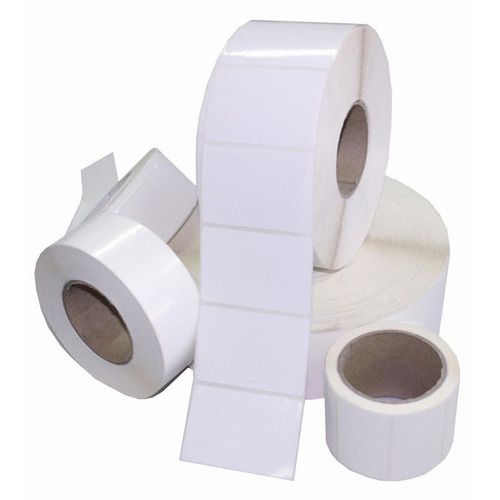 Four rolls of blank white adhesive labels in different sizes are displayed, with one roll partially unspooled to show rectangular labels—ideal packaging supplies to deliver organized labeling solutions.